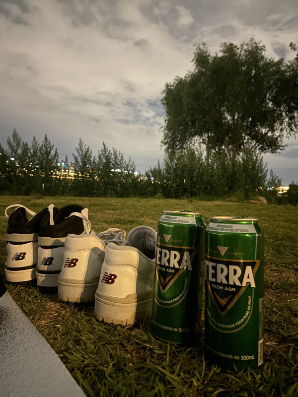 two pairs of shoes and two beers next to the river