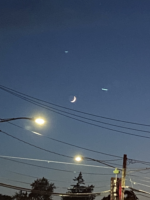 a crescent moon with street lights