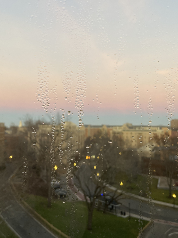 water droplets on a window with a glowing sunset in the background 